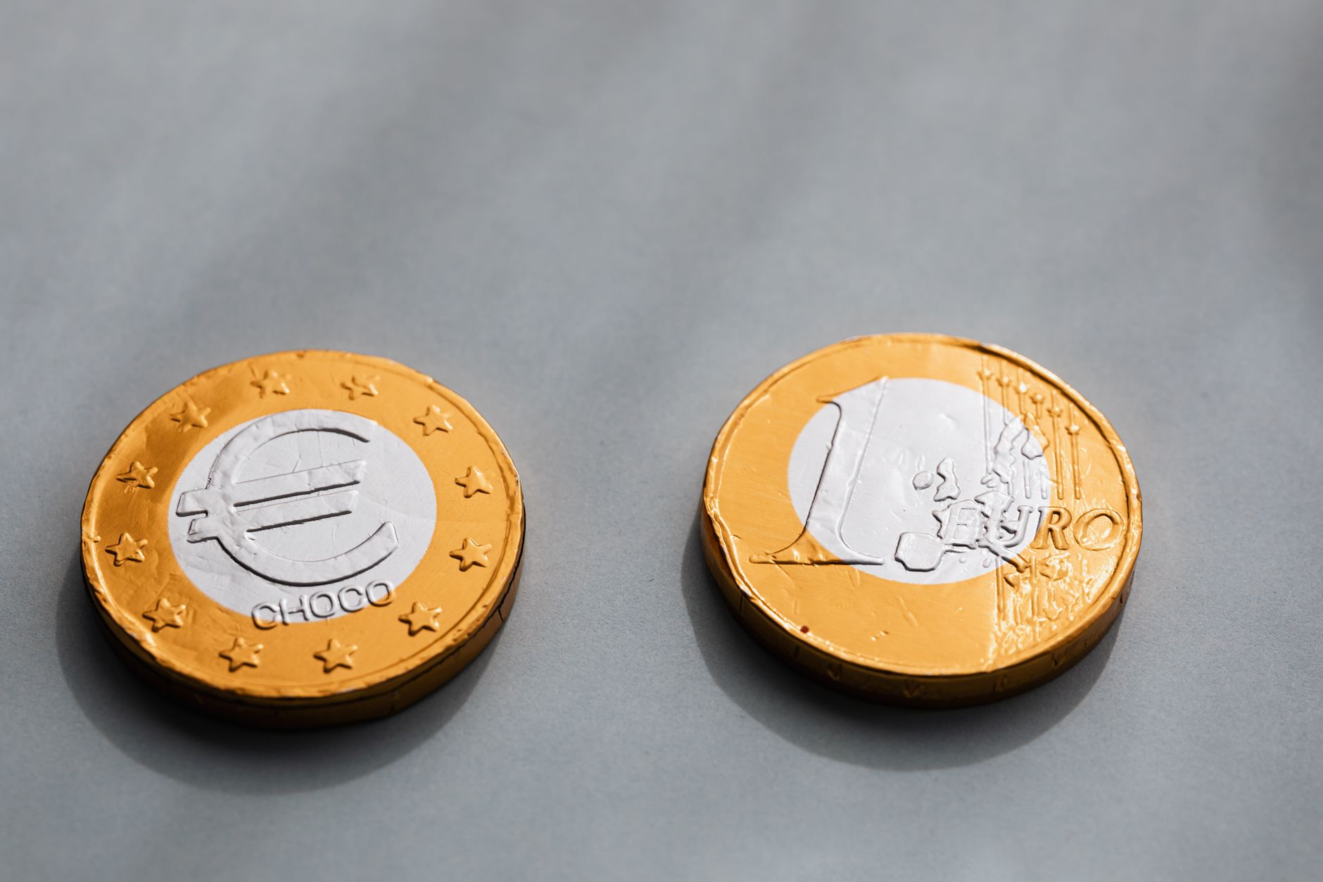a single gold coin resting on a pile of gray ash