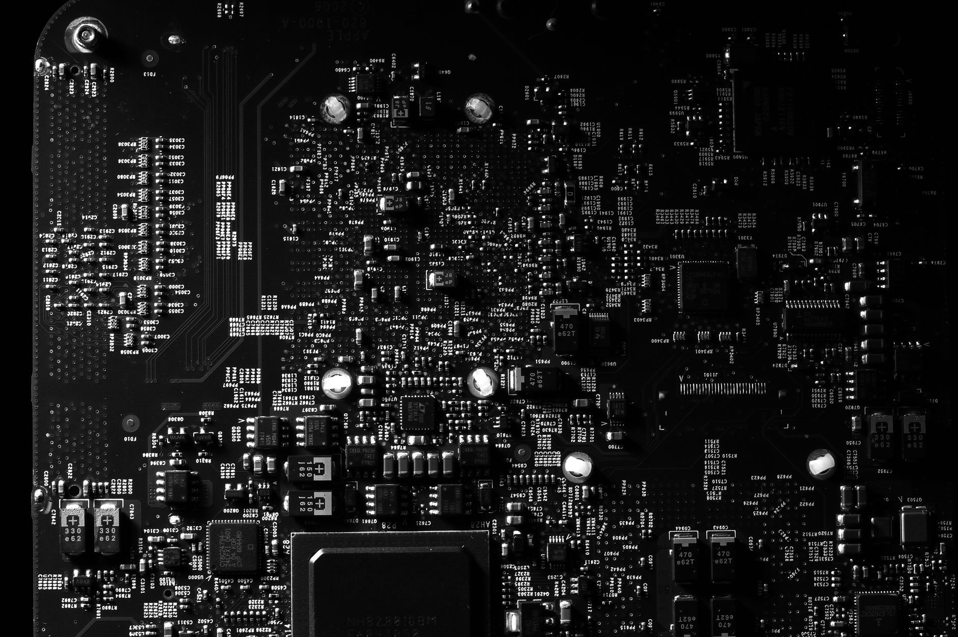 a single green circuit board on a dark wooden table