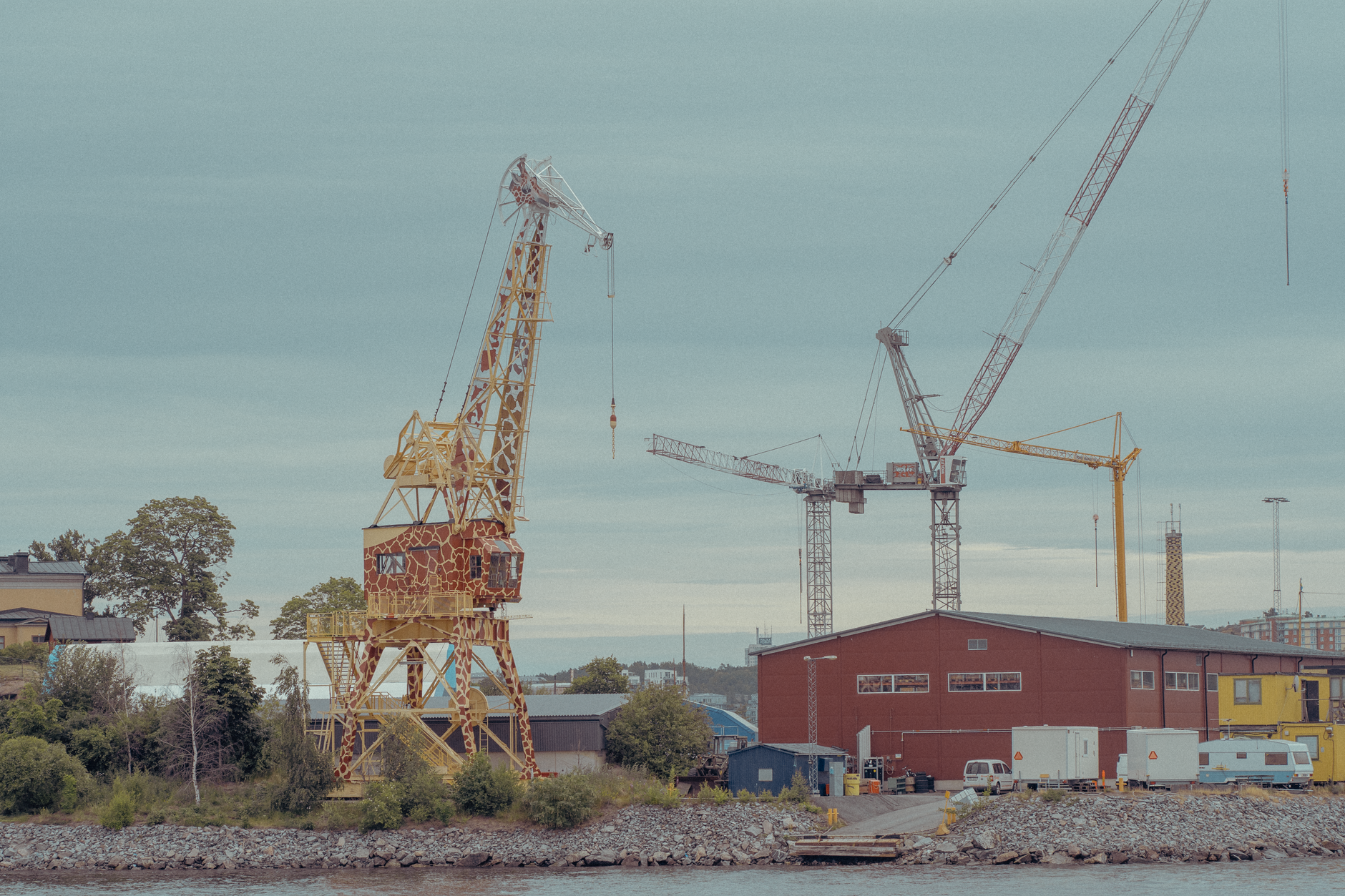 a giant yellow crane lifting a stadium seating section like a toy block