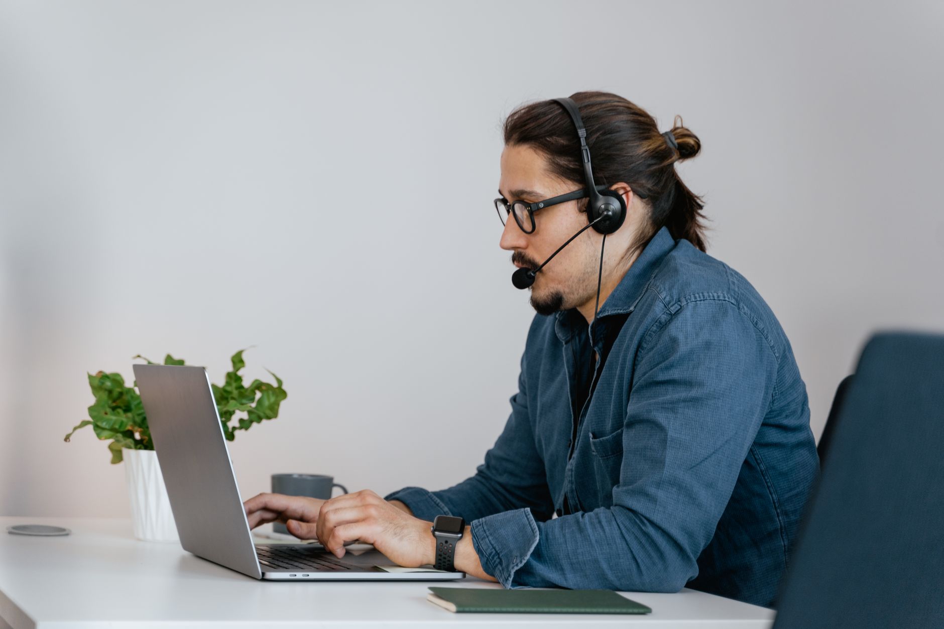a golden retriever wearing a headset sitting at a laptop