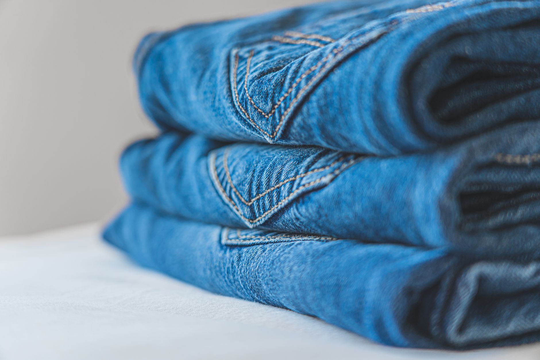 a stack of neatly folded black t-shirts on a white table